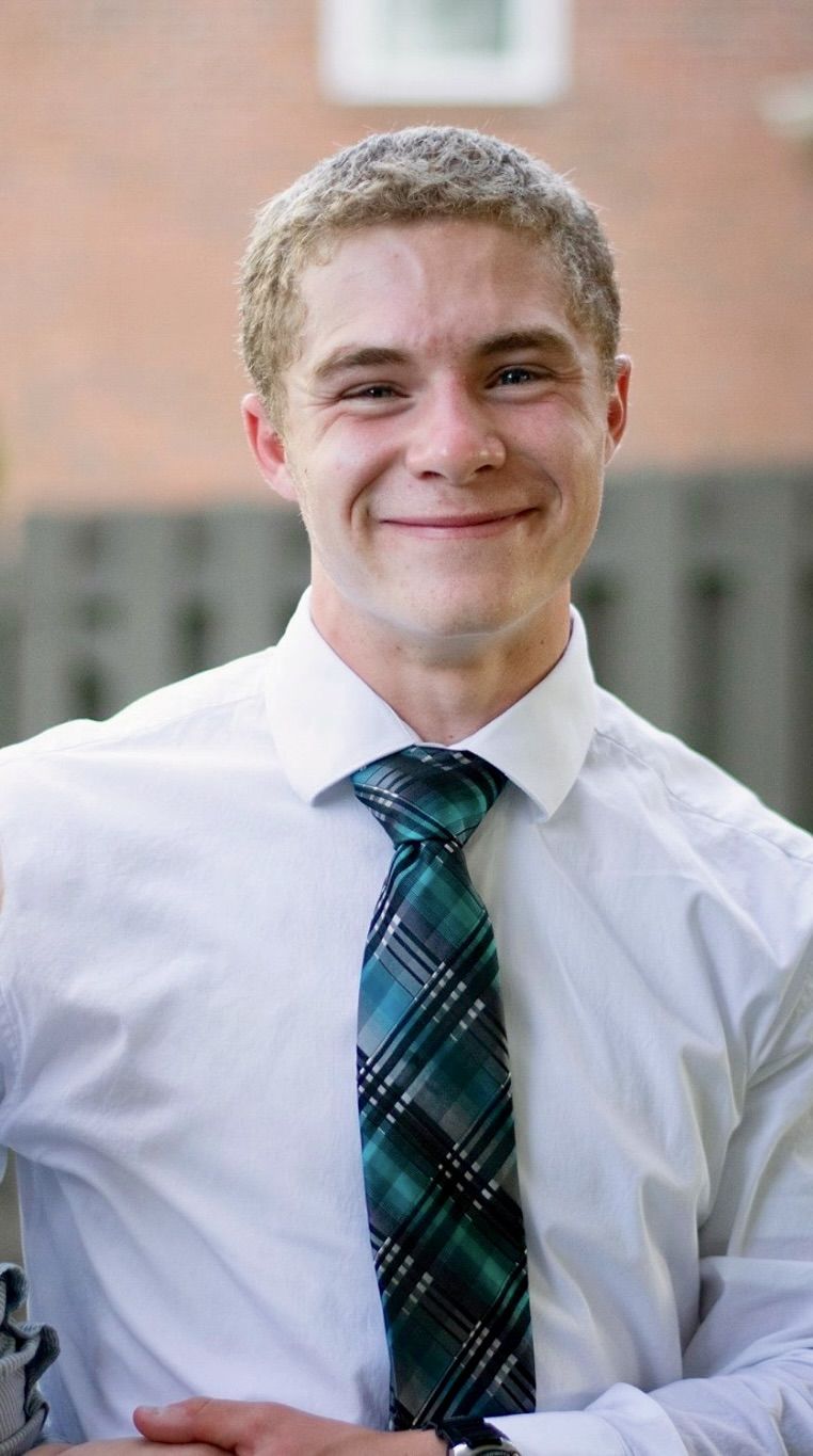 Coach smiling in a white shirt and tie